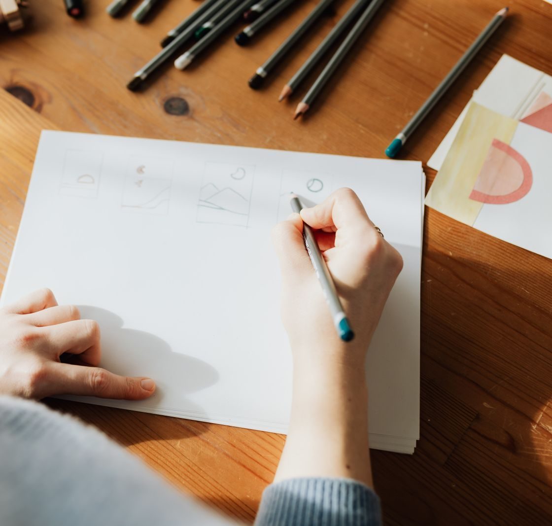 A freelance illustrator's desk with original drawings and a folder, contents not legible.
