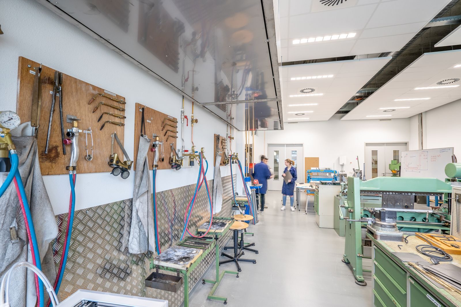 A bright Texas innovation workspace where a prototype sits on a workbench in the foreground and finished products line the shelves behind.